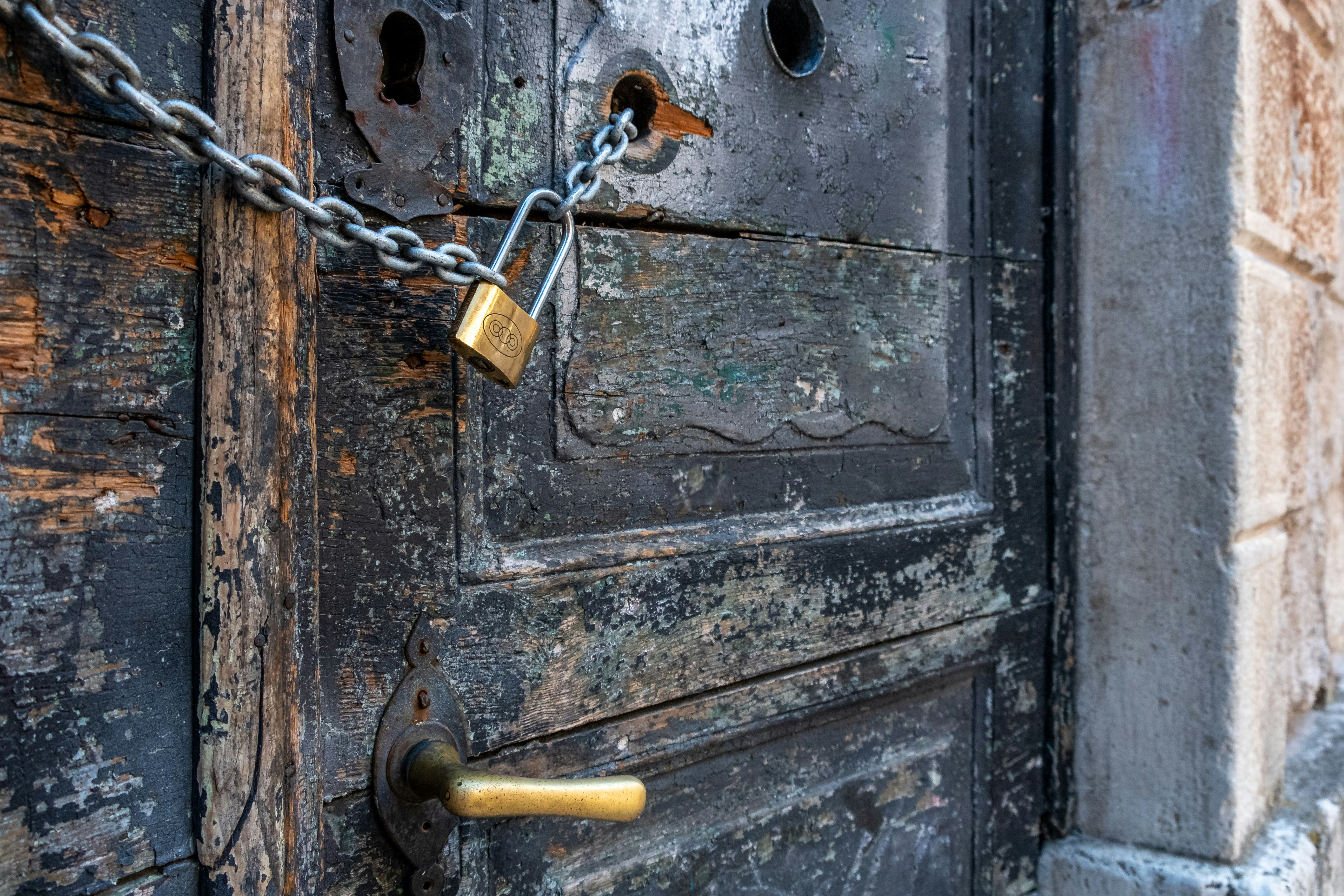 Old wooden door locked with simple padlock
